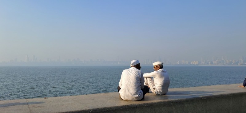 Two men sitting by the sea
