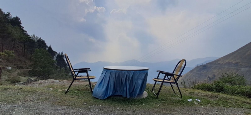 Two chairs and a table on a mountainside