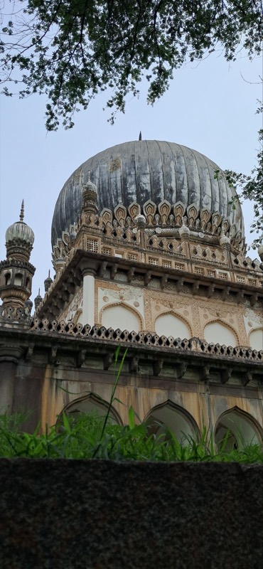 A domed tomb behind trees